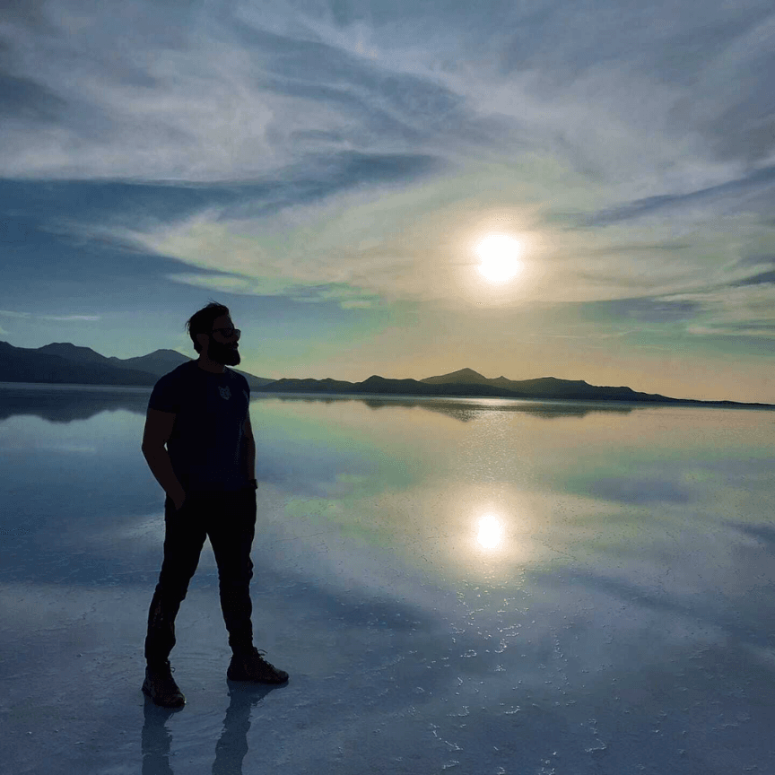Três viajantes sobre uma locomotiva enferrujada no Cemitério de Trens de Uyuni